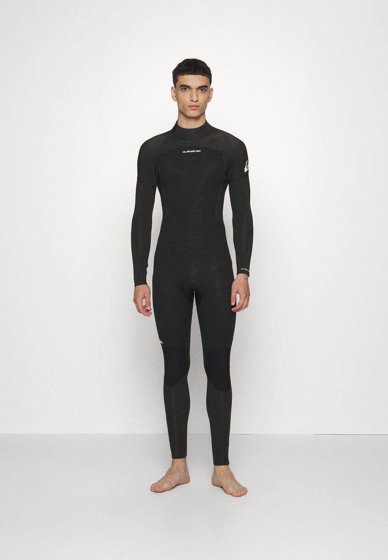 Mutino nero con maniche lunghe e gambe lunghe. Presenta una texture liscia, un design aderente e pannelli neri a contrasto sulle cosce.