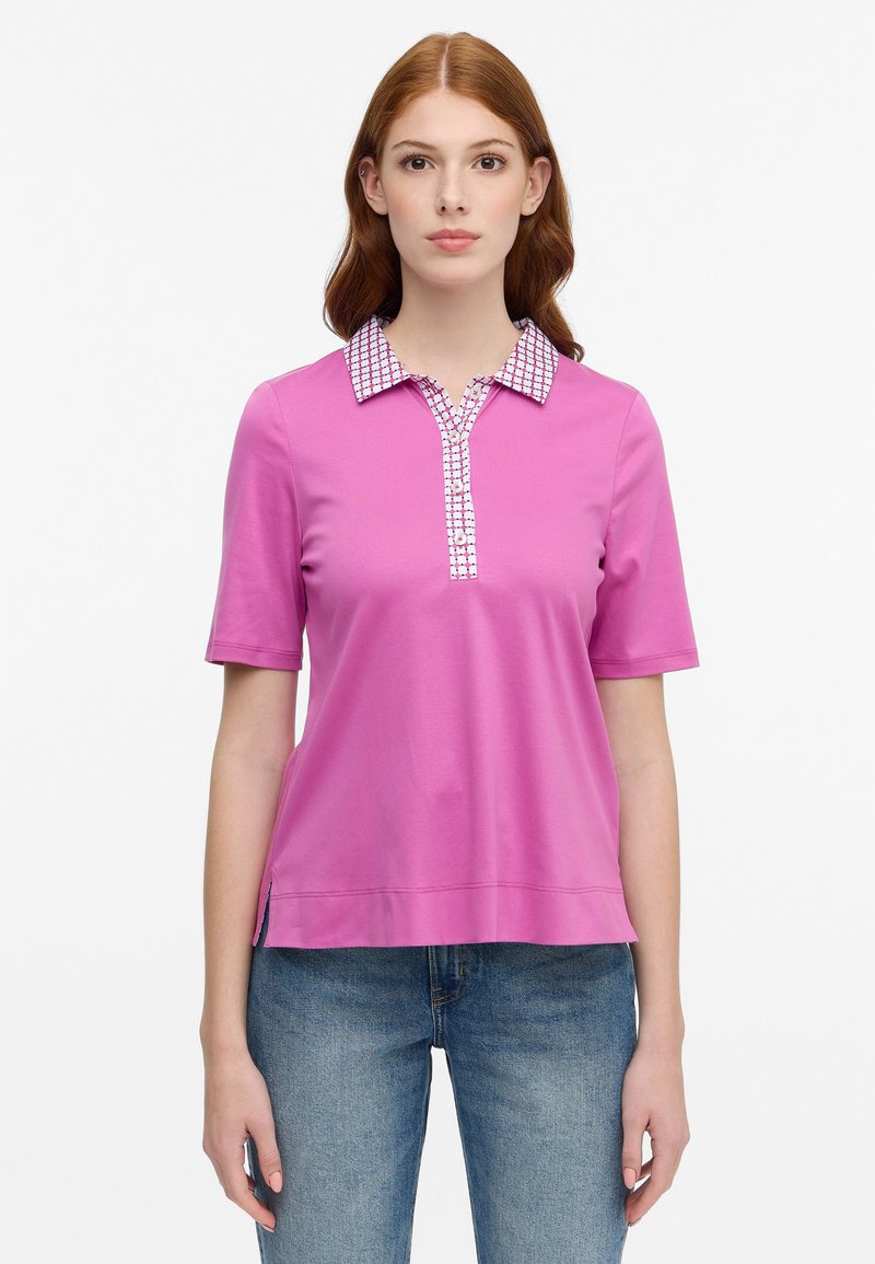 Rosa kurzärmliges Poloshirt mit einem gemusterten Kragen und Knopfleiste. Hergestellt aus einem glatten, leichten Stoff.