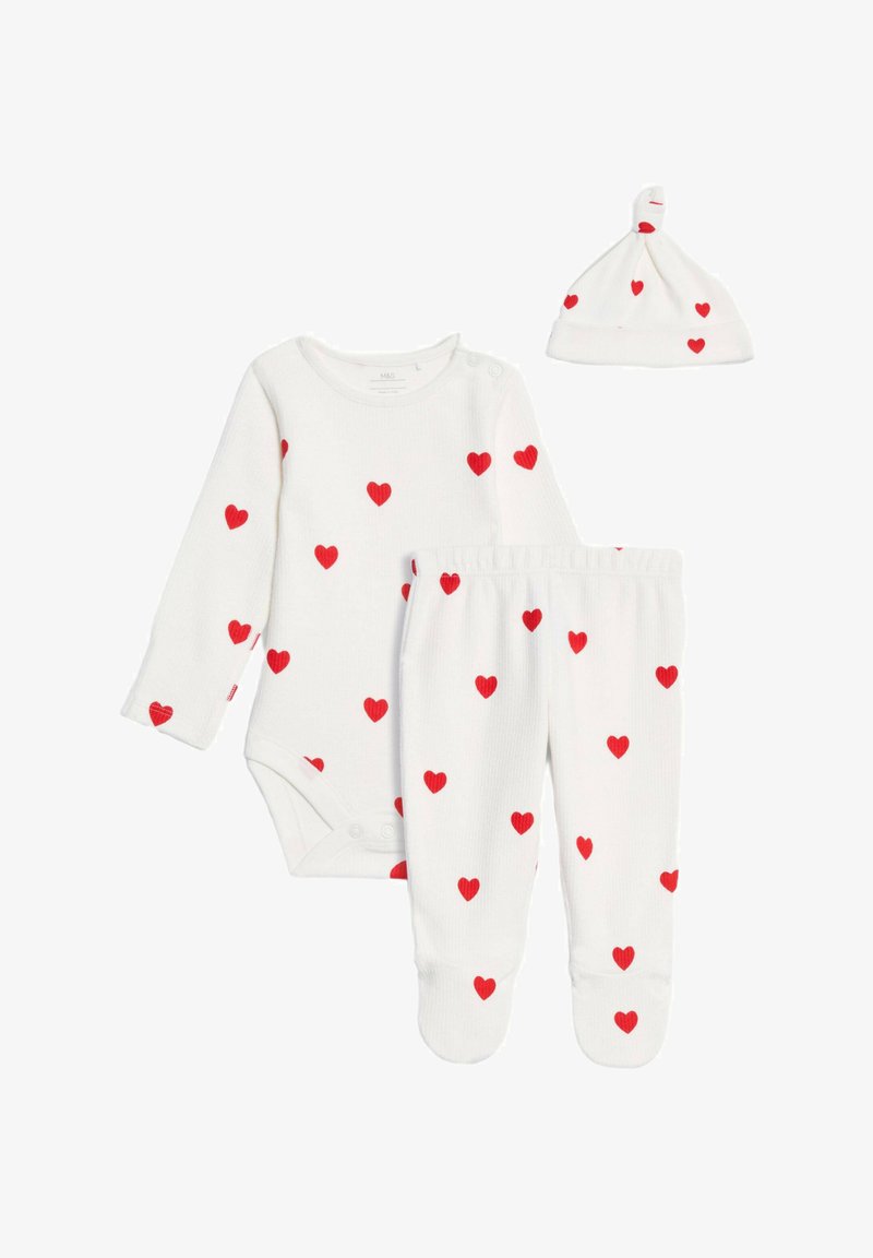 Vit babydress-set med röda hjärt-mönster, inkluderande en långärmad bodysuit, fotade byxor och en matchande hatt. Mjuk ribbad textur.