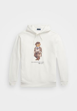 Hvit hettegenser med fronttrykk av en bjørn som har på seg flat cap, blazer, genser og skjerf, holder et rullet papir, med teksten Polo Bear by Ralph Lauren.