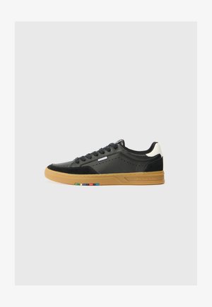 Schwarze Leder- und Wildledersneaker mit einer Gummisohle, die über perforierte Details, ein Schnürdesign und einen mehrfarbigen Akzent in der Nähe der Sohle verfügt.
