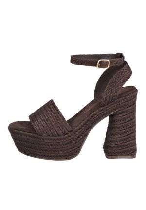 Sandalia de plataforma tejida marrón con tacón alto grueso y correa en el tobillo con hebilla dorada, en ángulo para mostrar el lado exterior.