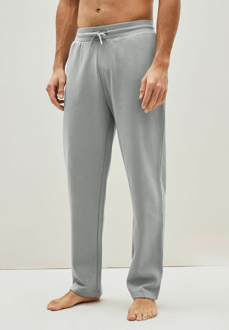 Pantalones de chándal grises hechos de una tela suave, con una cinturilla elástica con cordón, costuras laterales y un corte relajado. Sin bolsillos.