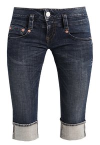 Tummanpesun denim capri-farkut, joissa on käännetyt lahkeet, viisi taskua, metallinapit ja erottuvat ompeluyksityiskohdat.