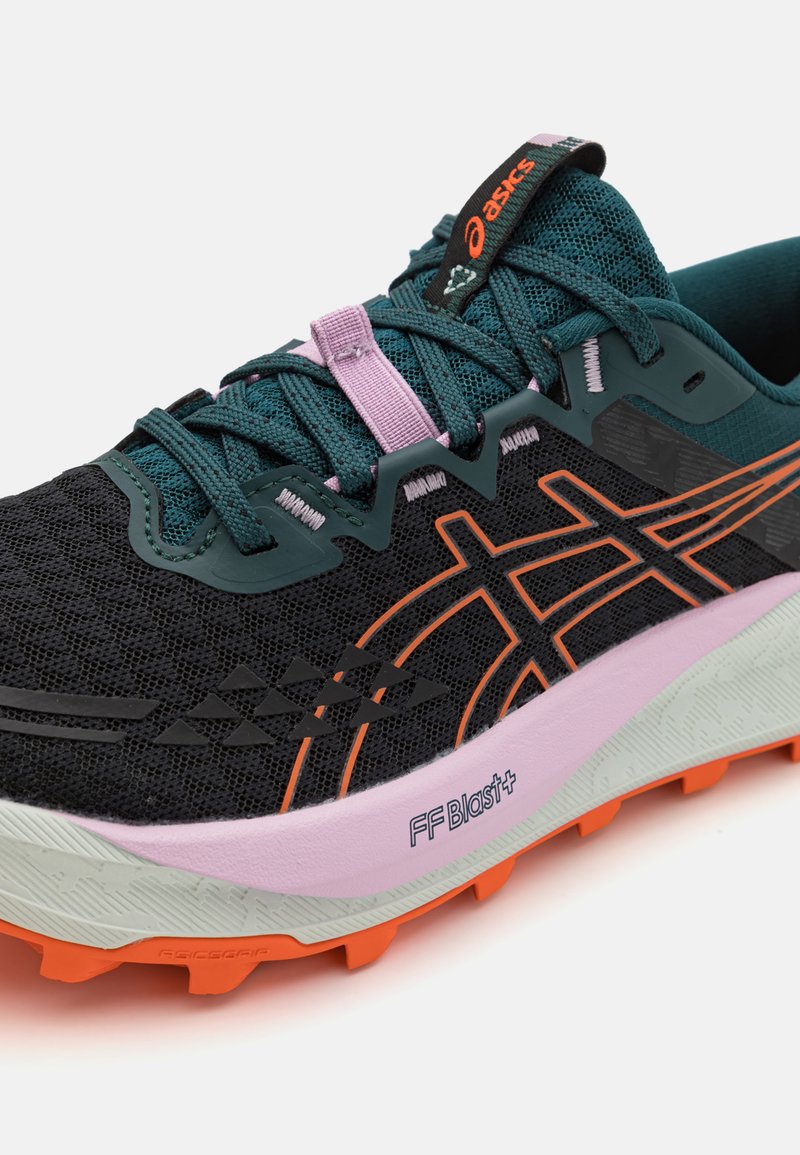 Scarpa da corsa nera con accenti verdi e rosa, tomaia in rete, suola arancione e dettagli testurizzati. Presenta un logo distintivo e un sistema di allacciatura.