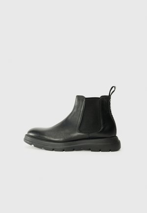 Black Chelsea boots made of smooth leather, featuring elastic side panels, a cushioned sole, and a pull tab at the heel for easy wear.