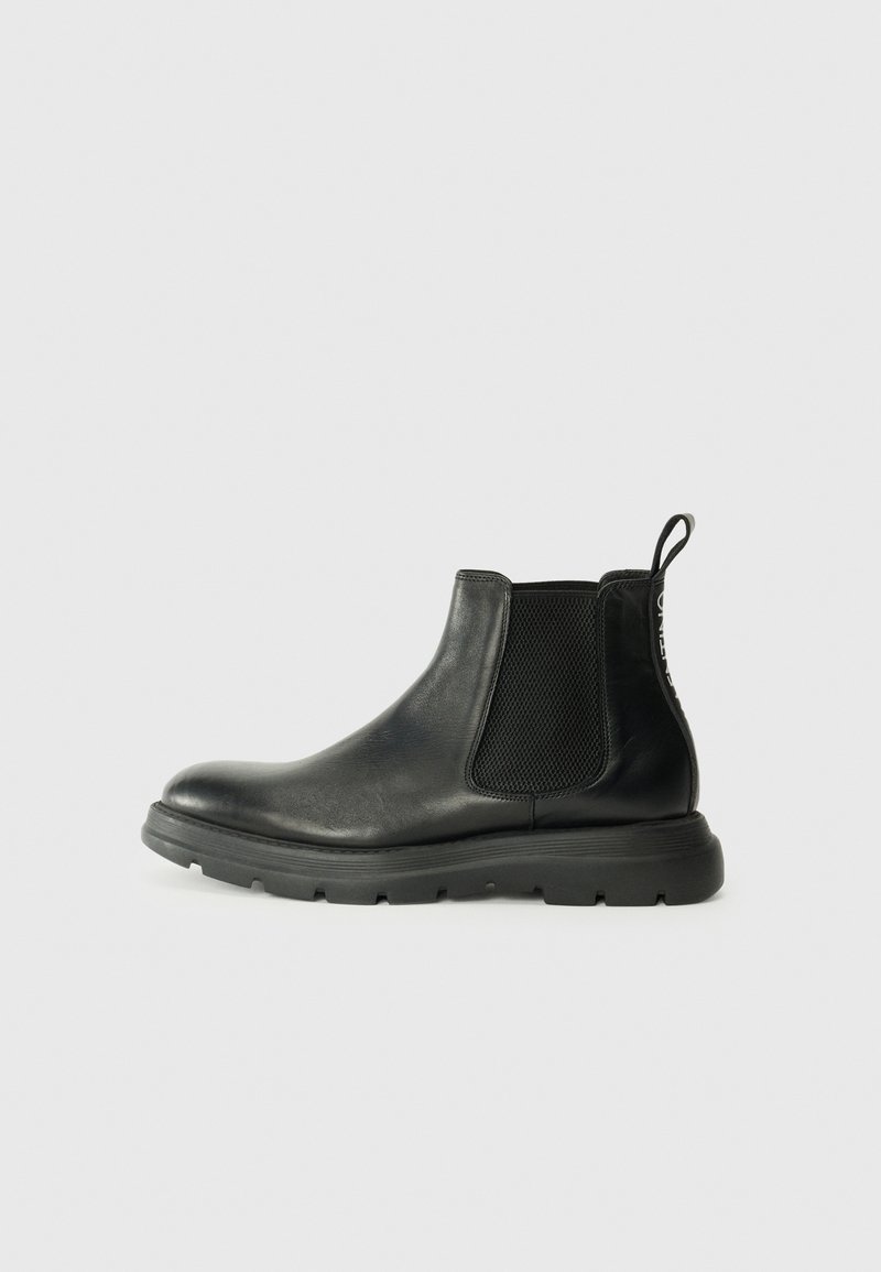 Bottines Chelsea noires en cuir lisse, dotées de panneaux latéraux élastiques, d'une semelle rembourrée et d'une languette au talon pour un enfilage facile.