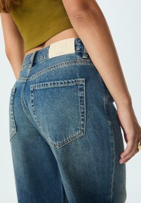 Svetlomodré džíny s vysokým pásom, s koženým štítkom s nápisom "D91" a dvoma zadnými vreckami s vyšívaným detailom.