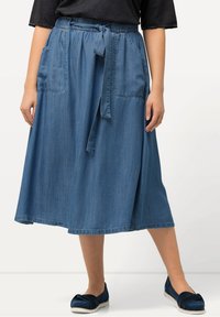 Ljusblå denim midi kjol. Har en elastisk midja med ett knytbälte, två framfickor och en svängd A-linjeform.