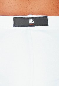 Weiße Stoffunterhose mit einem schwarzen Etikett, auf dem "HIS" in weißer Schrift und einem roten Akzentstreifen steht. Glatte Textur, elastischer Sitz.