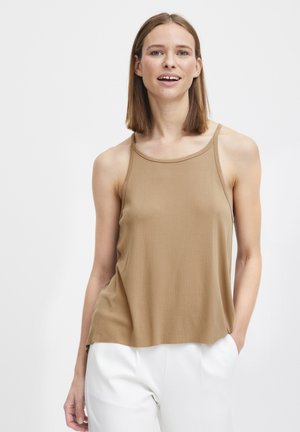 Ärmelloses Top in Tan aus einem weichen, glatten Stoff mit einem runden Ausschnitt und lockerer Passform. Das Model trägt weiße, weit geschnittene Hosen.