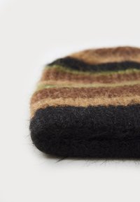 Bonnet en laine avec une texture douce et duveteuse, arborant des rayures horizontales dans des teintes de noir, marron et vert ; bord arrondi et replié.