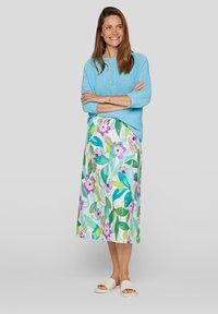 Light blue knitted sweater, floral patterned long skirt with purple and green hues, and beige slide sandals.