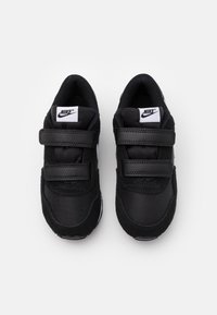 Baskets Nike noires en textile et en daim, avec deux sangles Velcro et un logo blanc sur la languette.