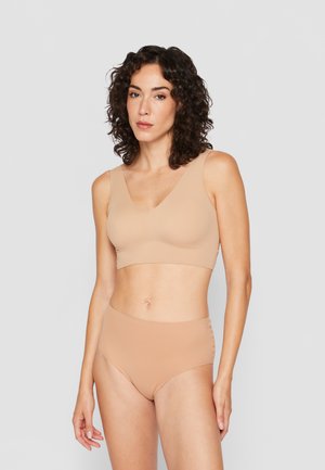 Beige seamless bralette met een V-hals en brede banden, gecombineerd met hoge taille beige onderbroek, beide van een gladde, elastische stof.