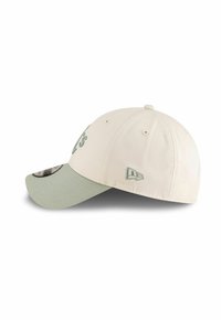 Gorra de béisbol en color crema con un visera curva de color verde claro. Presenta un logo bordado en la parte delantera y lateral, y un forro interior con patrón.