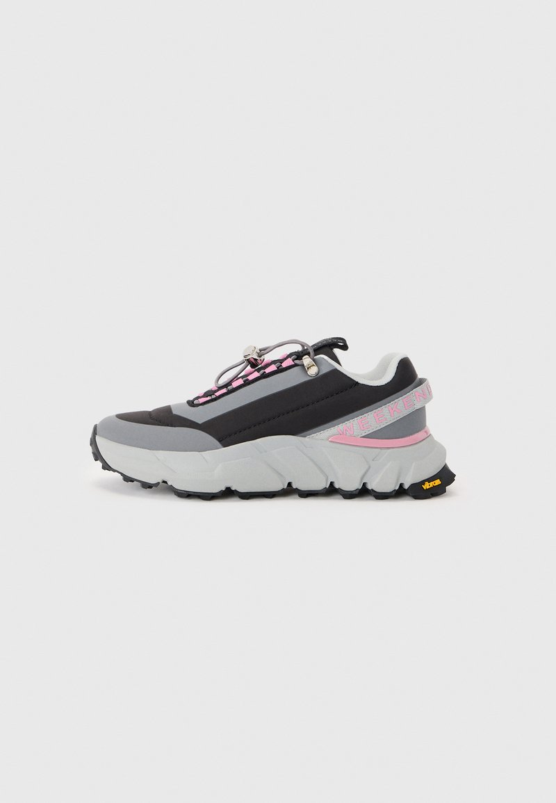 Sport shoes with a black and grey upper, textured mesh, vibrant pink accents, a thick sole, and reflective hardware for a secure fit.