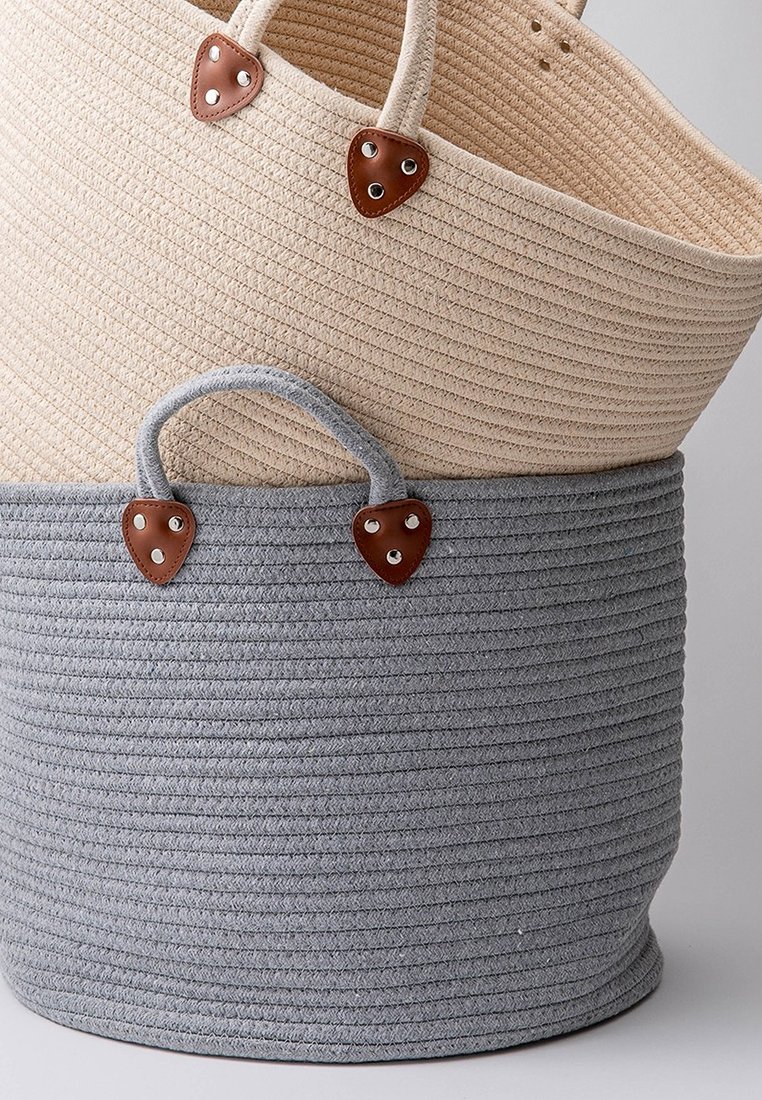 Seil-Aufbewahrungskörbe in Beige und Grau mit strukturierten Oberflächen. Beide haben braune Lederdetails und Griffe für einen einfachen Transport.
