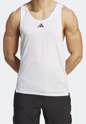 Débardeur blanc en tissu léger, doté d'un col rond et d'un petit logo Adidas noir sur la poitrine.