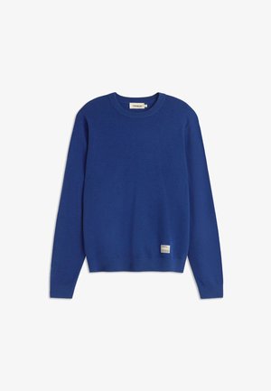 Suéter azul de cuello redondo hecho de una tela suave, con mangas largas y una etiqueta en el lado inferior izquierdo. Textura suave y color uniforme.