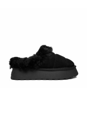 Zapatilla negra de plataforma sin cordones con suela gruesa y forro de piel suave alrededor del tobillo y la abertura, diseñada para la comodidad en interiores.