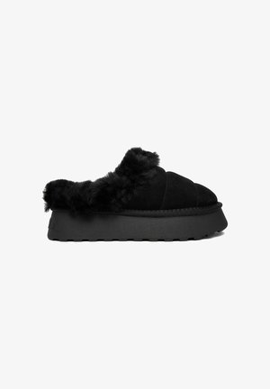 Black slip-on platform slipper with thick sole and plush fur lining around the ankle and opening, designed for indoor comfort.