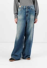 Wijde jeans in een medium wassende denim met vervaging, met een hoge taille, vijf-pocket ontwerp en contrasterende stiksels. Geaccentueerd met een logo label.