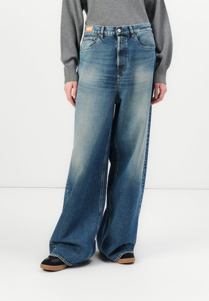 Wijde jeans in een medium wassende denim met vervaging, met een hoge taille, vijf-pocket ontwerp en contrasterende stiksels. Geaccentueerd met een logo label.