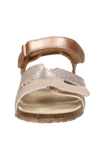 Vorderansicht eines einzelnen roségoldenen Sandals mit texturierten Riemen und einer Korksohle vor weißem Hintergrund.