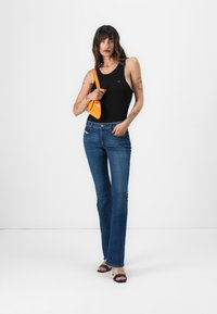 Bodysuit sans manches noir, jean flare bleu, sac à main orange, talons ouverts noirs. Design minimaliste axé sur le prêt-à-porter décontracté.