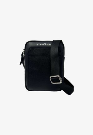 Borsa a tracolla nera con superficie texture, chiusura a zip, tracolla regolabile e dettagli in argento. Logo nella parte superiore anteriore. Forma rettangolare compatta.