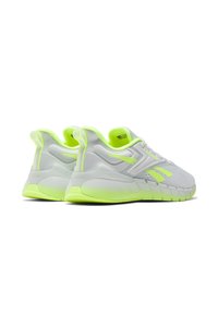 Zapatillas deportivas blancas con acentos en verde neón, cuentan con una parte superior de malla transpirable, suela texturizada y un diseño de talón distintivo.