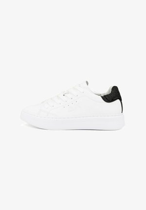 Zapatilla blanca con puntera redonda, parte superior de sintético suave, diseño de cordones y acento negro en la parte trasera con detalles texturizados.