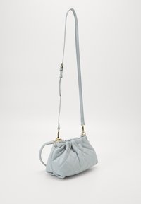 Pikowana jasnoniebieska skórzana torebka z marszczonym górnym brzegiem i regulowanym paskiem. Złote dodatki podkreślają design. Kompaktowy kształt.