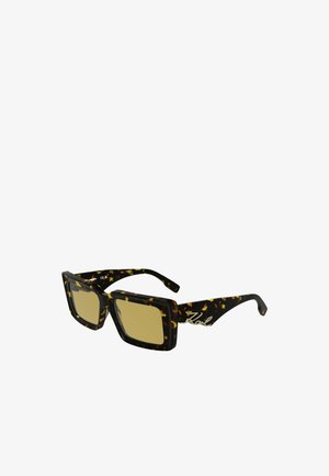 Schwarz- und braun-getigerte Sonnenbrille mit quadratischen Gläsern, gelb getönten Gläsern und metallischen Logo-Details an den Bügeln.