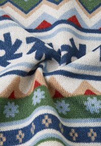 Tecido de malha com um padrão geométrico multicolorido, com realces em azul, vermelho, verde e creme; textura suave com motivos de floco de neve proeminentes.