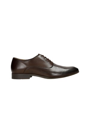 Brown leather dress shoe with a rounded toe, smooth texture, six lace eyelets, and a low heel. Minimalist design with subtle stitching.