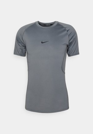 Camisa deportiva gris de manga corta y ligera, con cuello redondo, costuras cosidas y un pequeño logo negro de Nike en el pecho.