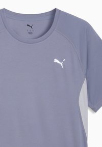 T-shirt de sport violet clair avec tissu texturé, manches courtes et accents gris contrastants. Présente un logo Puma blanc sur la poitrine.