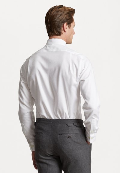 White long-sleeve shirt with a high collar, paired with gray trousers featuring a belt and two back pockets. Smooth texture, tailored fit.