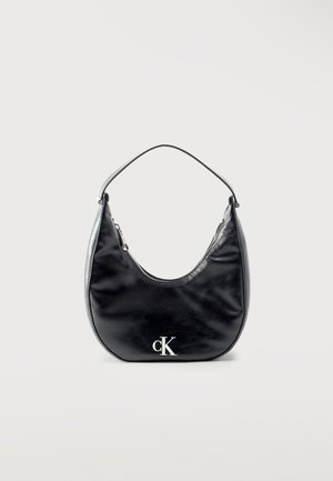 Borsa a mezzaluna di pelle nera con tracolla corta e logo "cK" in argento sul davanti, chiusura con cerniera sulla parte superiore.