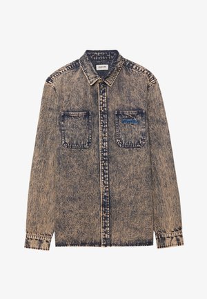 Vaaleansininen farkkupaita, jossa on haalistunut beige, kaksi rintataskua, nappikiinnitys ja karkea kuviointi koko paidassa.