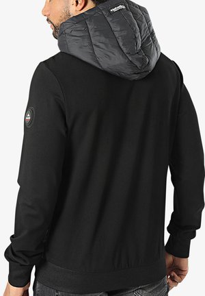 Sweatshirt noir avec une capuche grise matelassée. Présente un patch de marque sur l'épaule gauche et des poignets et un ourlet côtelés pour un ajustement confortable.