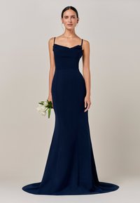 Dolg mornarsko modri večerni oblek v teksturirani tkanini, oprijet zgornji del z dekoltejem v obliki žlebu, tankimi naramnicami in razširjeno krilo, ki sega do tal.