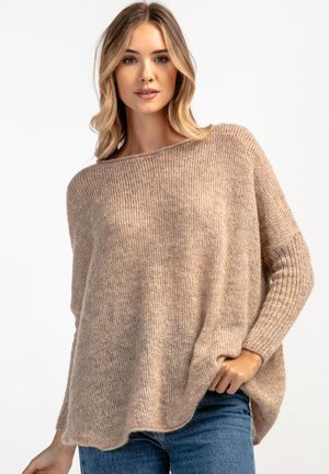 Beżowy sweter z dzianiny o luźnym kroju, z prążkowanymi rękawami i szerokim dekoltem. Miękka tekstura z lekko puszystym wyglądem.