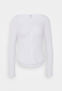 Top bianco a maniche lunghe con scollo rotondo, chiusura frontale con bottoni e silhouette attillata. Tessuto morbido e orlo curvo.