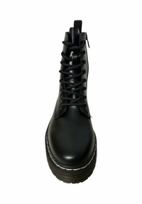Botín negro de cordones con acabado brillante, puntera redonda y suela gruesa y estriada con costuras blancas. Cierre de cremallera en el lateral.