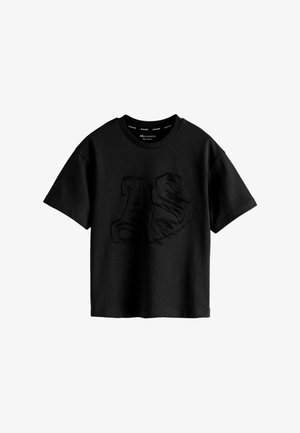 Czarny t-shirt z krótkim rękawem i okrągłym dekoltem, z dużymi, teksturowanymi literami "AS" wyhaftowanymi na środku z przodu.