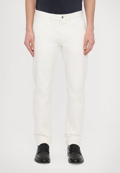 Fehér, slim fit farmernadrág klasszikus öt zsebes dizájnnal, diszkrét varrásokkal, és cipzárral illetve gombos záródással.