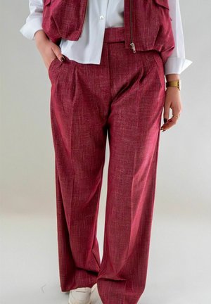 Bordeaux geklede broek met een relaxed fit, met plooien en zijzakken, gecombineerd met een wit shirt. Eenvoudig ontwerp en zacht materiaal.